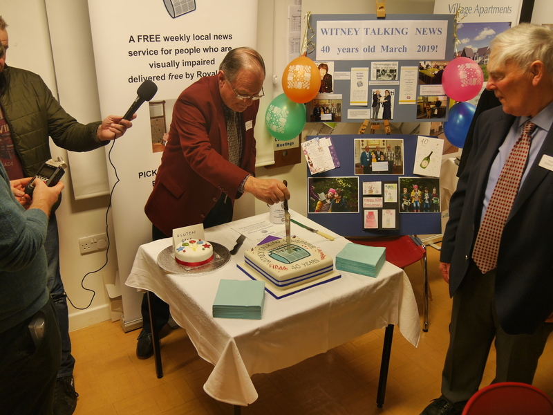 Chairman Peter Bee cuts the cake under the watchful eye of Secretary, Peter Bee, as Radio Oxford presenter, Simon Oliver records his speech.
